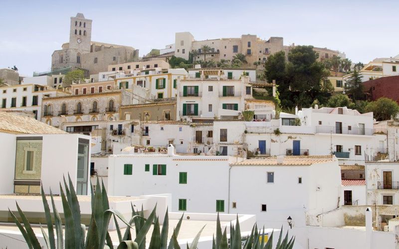 Vista de Dalt Vila en Ibiza, con casas blancas, arquitectura mediterránea y la ciudad histórica elevada sobre el casco antiguo.